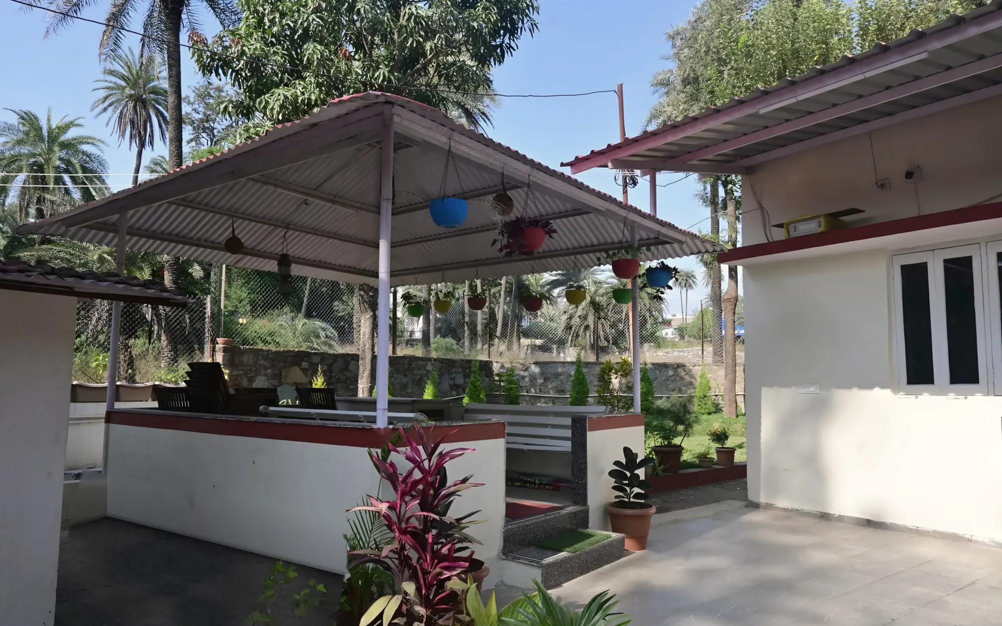 Gazebo with hanging plant pots among the palms